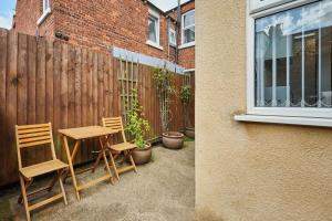a table and two chairs sitting next to a fence at Cromwell House, Sleeps 8, Central Location in Filey