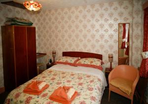 een slaapkamer met een bed met twee handdoeken erop bij The Northwood in Colwyn Bay