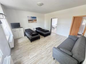 新勃兰登堡Ihlen Appartements的客厅里有一张沙发和两把椅子