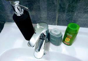 ein Waschbecken mit Wasserhahn und anderen Badezimmerartikeln in der Unterkunft Dnevna Soba in Doboj