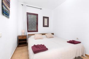 a bedroom with a white bed with red towels on it at Home2Book Casa Kiky - Cosy Villa with Jacuzzi in La Oliva