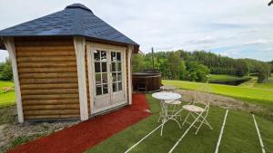 a small cabin with a table and chairs at Järvevaatega Puhkemajake in Nüpli
