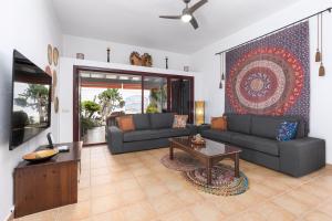 a living room with a couch and a table at Home2Book Casa Kiky - Cosy Villa with Jacuzzi in La Oliva