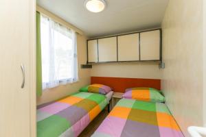 two twin beds in a room with a window at Mobile Homes Romantik in Labin +22 photos