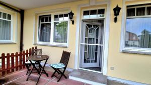a table and two chairs sitting outside of a house at Villa Viktoria Whg 2 - "Herzmuschel" in Kolpinsee