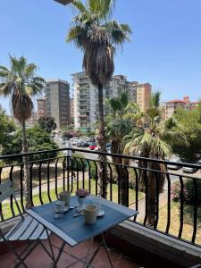a blue table on a balcony with palm trees at Allegracore Rental House in Catania