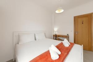 a bedroom with a white bed with two towels on it at Baleal Oceanviews in Ferrel +15 photos