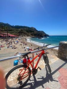 un vélo rouge garé sur une balustrade sur une plage dans l'établissement Casa De La Luz, à Carthagène