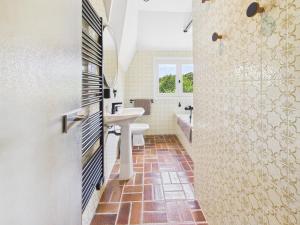 a bathroom with a sink and a toilet and a shower at -TY TAD - Magnifique Chaumiere entierement renovee in Névez +32 photos