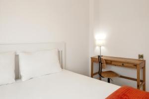 a bedroom with a bed and a desk with a lamp at Baleal Oceanviews in Ferrel