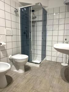 a bathroom with a toilet and a shower and a sink at The Giza House in Olbia