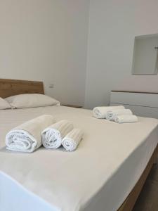 a bed with three rolled towels on it at The Giza House in Olbia