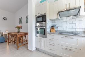 a kitchen with white cabinets and a wooden table at Ternemoyschool in Pájara +16 photos