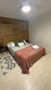 Un dormitorio con una cama grande con una manta marrón. en Villa Cardui. Casa de diseño con magníficas vistas, en Madrid