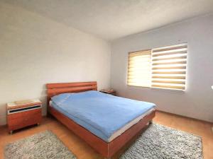 a bedroom with a bed and a window and two rugs at Ilidza Nature Home in Sarajevo