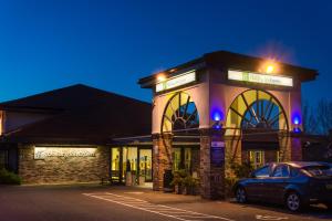 ピーターバラにあるHoliday Inn Express Peterborough by IHGの建物の前に車が駐車されている