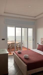 a bedroom with a bed and a view of the ocean at Rays View Moulay Bousselham in Moulay Bousselham