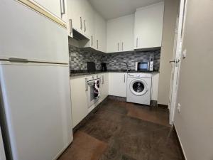 a kitchen with white cabinets and a washer and dryer at YourHouse Oasis Urbano in Ourense
