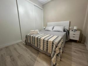 a bedroom with a bed with a striped blanket at YourHouse Oasis Urbano in Ourense