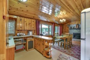 a kitchen with wooden walls and a dining room with a table at Cabin 600 to Manistee Lake Private Shared Access in Kalkaska