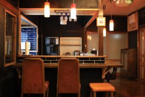 a kitchen with a bar with chairs and a table at WAVILLA mihata cho in Yamagata