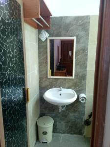 un bagno con lavandino, WC e specchio di Fazadmauna a Sembalun Lawang Altre 17 foto