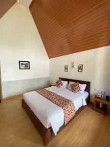 una camera da letto con un letto grande con soffitto in legno di Fazadmauna a Sembalun Lawang
