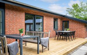 a patio with a table and chairs on a wooden deck at 3 Bedroom Beautiful Home In Tarm in Tarm +11 photos