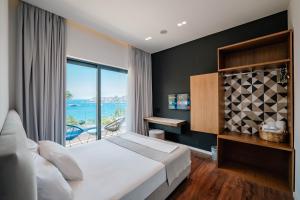 a bedroom with a large bed and a large window at Kanes Boutique Hotel in Sarandë