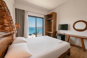 a bedroom with a bed and a view of the ocean at Kanes Boutique Hotel in Sarandë