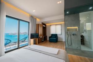 a hotel room with a bed and a glass shower at Kanes Boutique Hotel in Sarandë