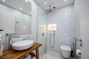 a white bathroom with a sink and a shower at Kanes Boutique Hotel in Sarandë