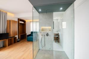 a bathroom with a shower with a glass wall at Kanes Boutique Hotel in Sarandë