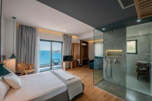 a bedroom with a bed and a glass shower at Kanes Boutique Hotel in Sarandë