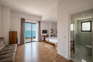 a bedroom with a bed and a view of the ocean at Kanes Boutique Hotel in Sarandë