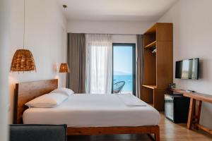 a hotel room with a bed and a television at Kanes Boutique Hotel in Sarandë