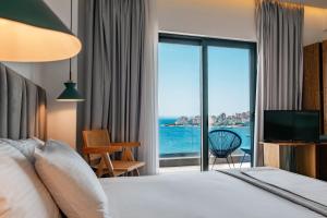 a bedroom with a bed and a view of the ocean at Kanes Boutique Hotel in Sarandë