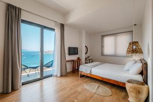 a bedroom with a bed and a view of the ocean at Kanes Boutique Hotel in Sarandë