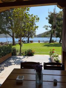 a wooden table and chairs with a view of the water at Pinelopi’s House in Porto Koufo