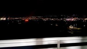 a view of a city at night with a white bench at Ilidza Nature Home in Sarajevo
