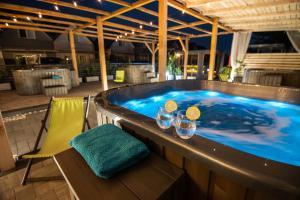 a jacuzzi tub on a patio with glasses of wine at Old Tree Villa & Restaurant in Oświęcim