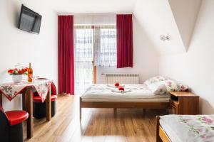 a small room with a bed and a table with a table at Willa Widokowa in Czarna Góra