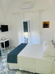 a bedroom with a large white bed and a window at B&B L'Agapanto in Capri