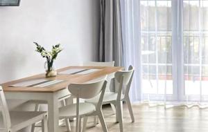 カルビアにあるStunning Apartment In Karwiaの木製のテーブルと白い椅子のあるダイニングルーム