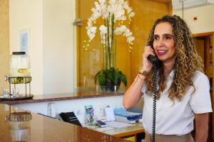a woman talking on a cell phone in a salon at Clube Porto Mos - Sunplace Hotels & Beach Resort in Lagos +37 photos