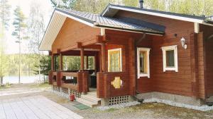 SavonrantaにあるLomavouti Cottagesの小さな木造のキャビン(ポーチ付)