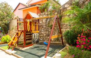 a playground in front of a house at Apartman Zora 2 by Villas Guide in Mošćenice
