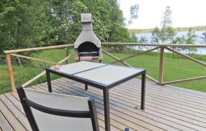 a table and a chair on a deck with a fireplace at Holiday Home Mörtekull Torup in Torup