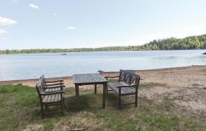 two benches and a picnic table next to a lake at Holiday Home Mörtekull Torup in Torup +7 photos