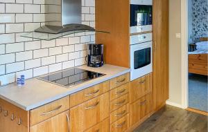 a kitchen with wooden cabinets and a stove at Holiday Home Mörtekull Torup in Torup